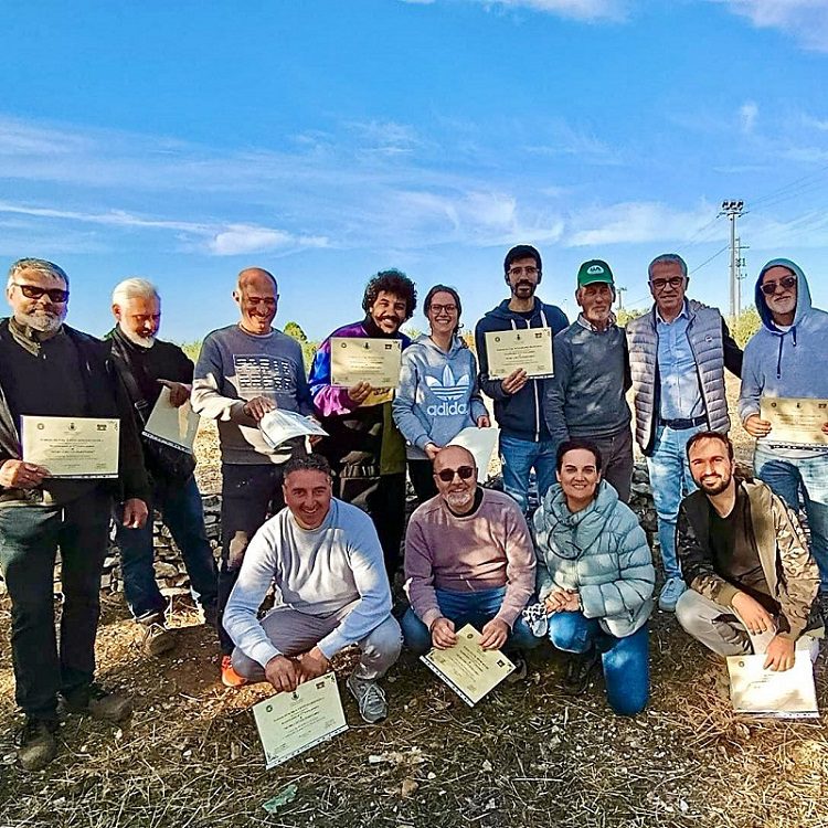 Gruppo di partecipanti al corso sui muretti a secco ad Acquaviva delle Fonti posa con gli attestati di partecipazione insieme al tutor Domenico Ferrulli.