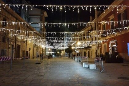 Luci natalizie illuminano la Area Pedonale Acquaviva di Piazza Dei Martiri la sera del 7 dicembre 2025.