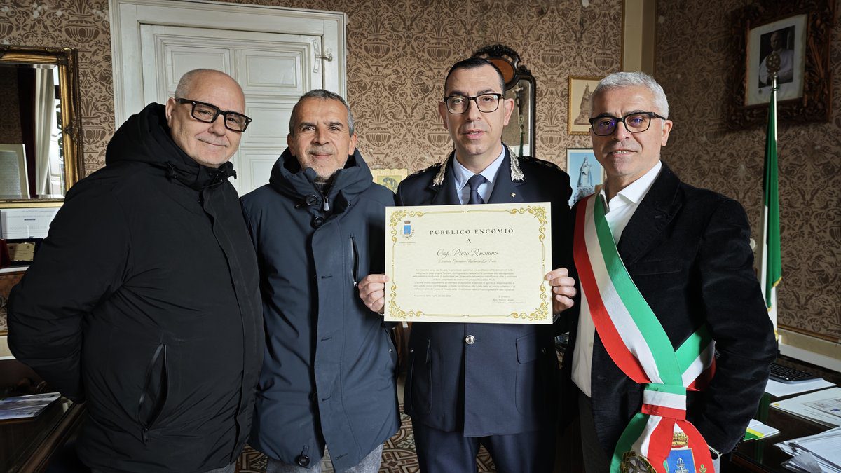 Il Sindaco Marco Lenoci consegna l'encomio ufficiale a Piero Romano insieme alle autorità locali ad Acquaviva delle Fonti.