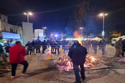 Celebrazione dei falò di San Giuseppe a Bitritto con la folla radunata attorno al fuoco.