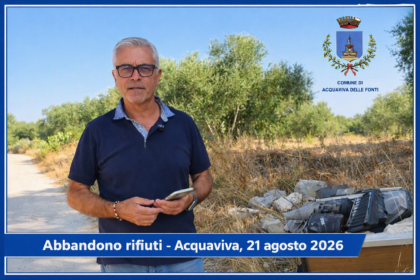 Abbandono rifiuti. Il sindaco di Acquaviva delle Fonti davanti a un cumulo di rifiuti abbandonati nelle campagne, con lo stemma del Comune sullo sfondo